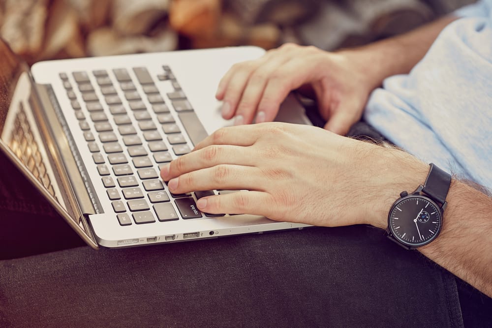 close up of hands typing on laptop.